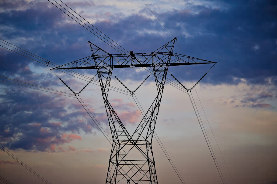 A high-voltage transmission tower against an evening sky