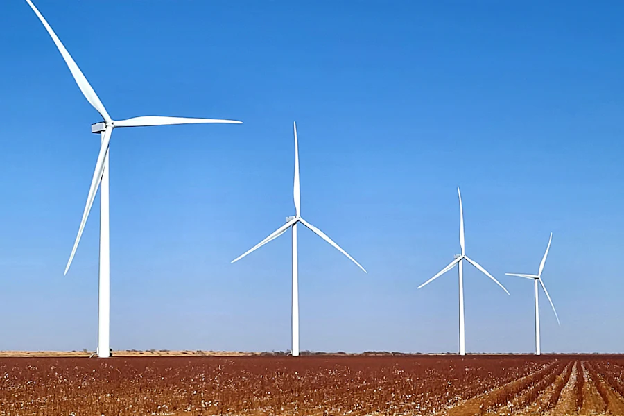 A row of wind turbines against a blue sky